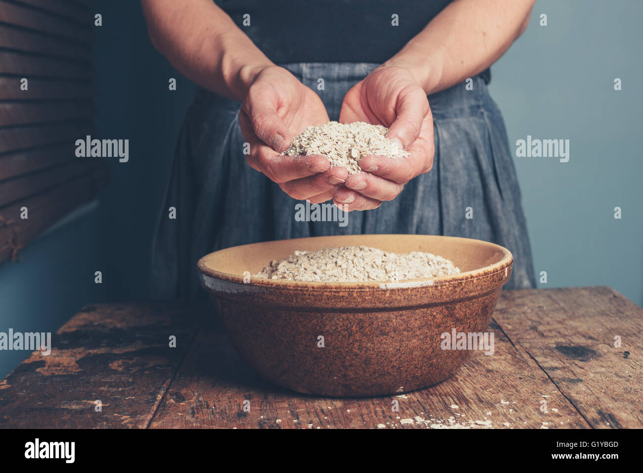 Una giovane donna è in piedi con una manciata di avena Foto Stock