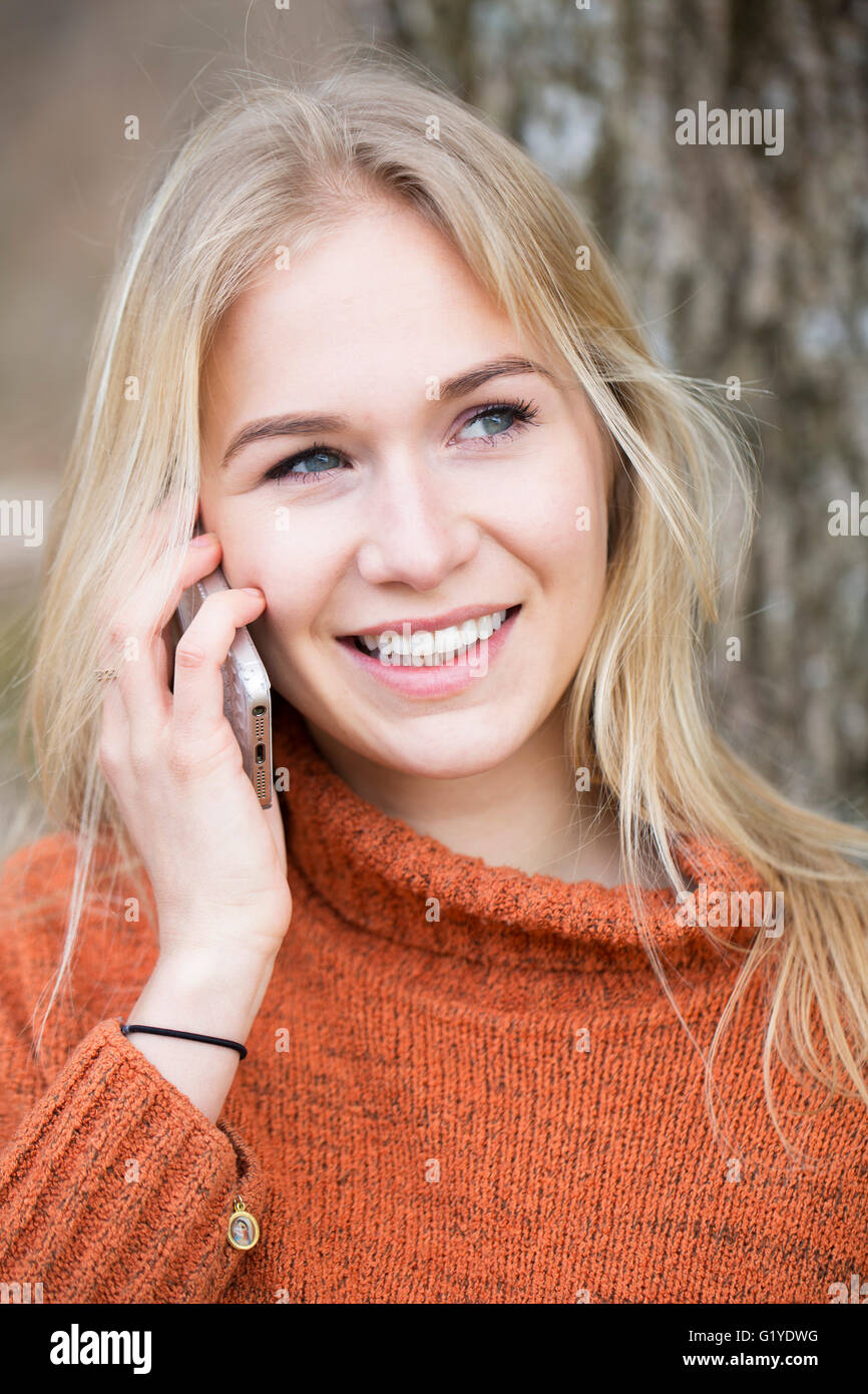 Giovane donna bionda telefonare con un cellulare Foto Stock