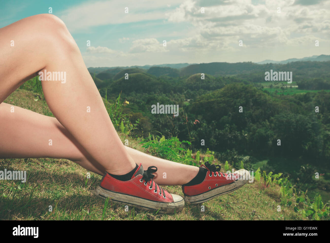 Le gambe di una giovane donna come lei è rilassante su una collina nei tropichi Foto Stock