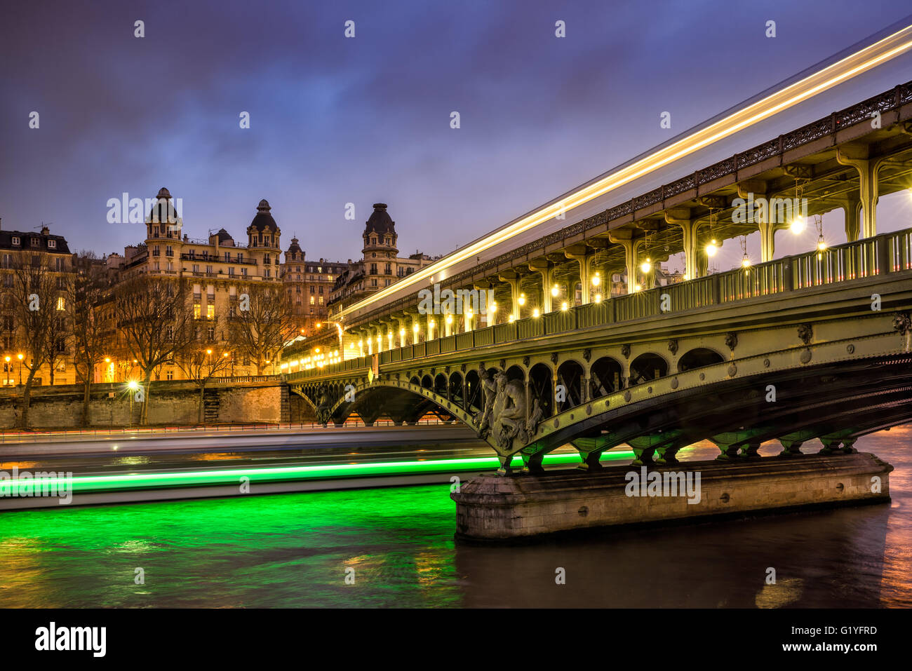 Parigi Bir-Hakeim bridge al crepuscolo con le nuvole e la luce delle scie di barche sul Fiume Senna. Sedicesimo arrondissement, 75016, Francia Foto Stock