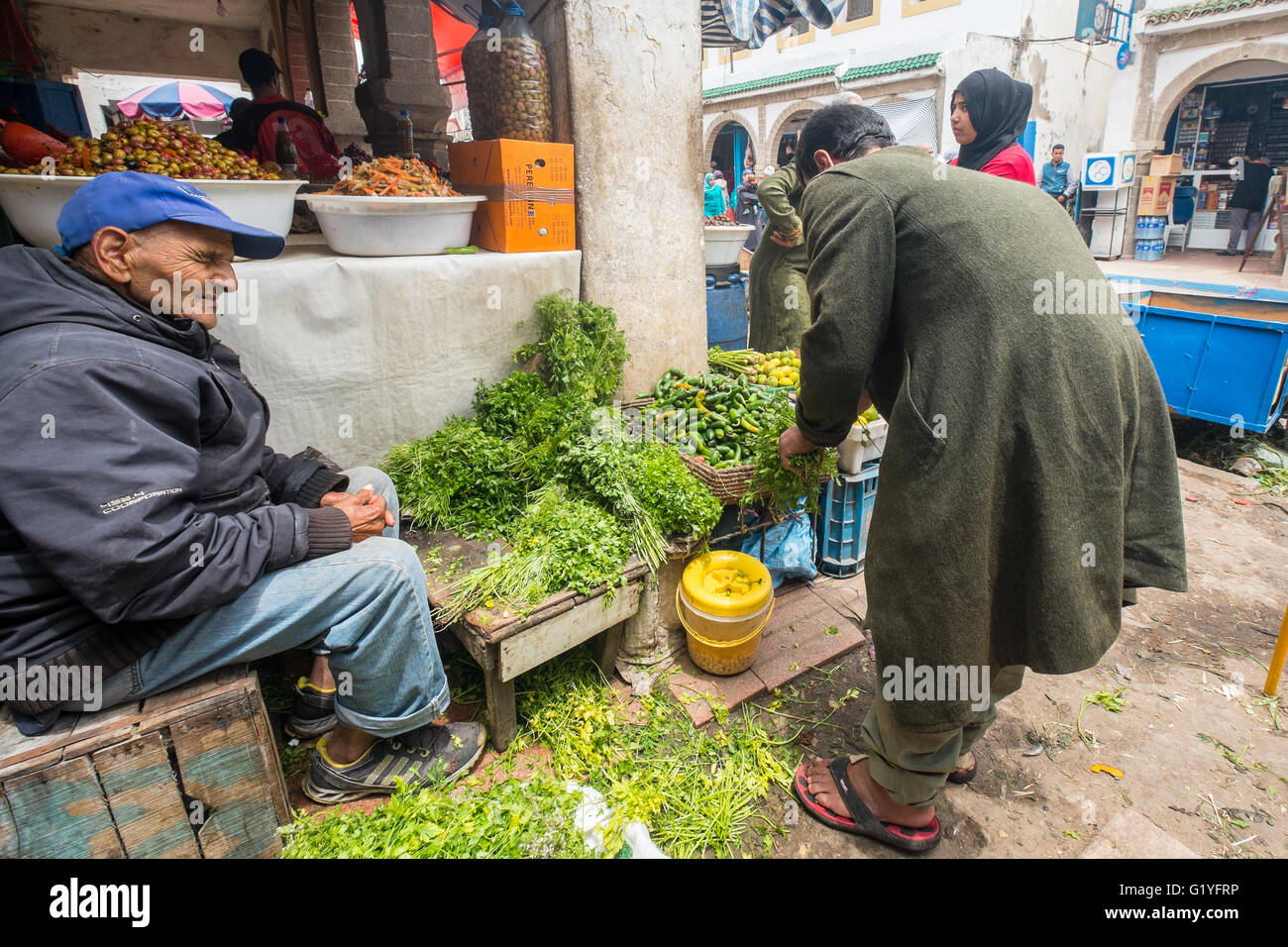 Marocchini andando sulle loro attività quotidiane all'interno della vivace medina (città vecchia) di Essaouira, Marocco, qui l'acquisto di menta Foto Stock
