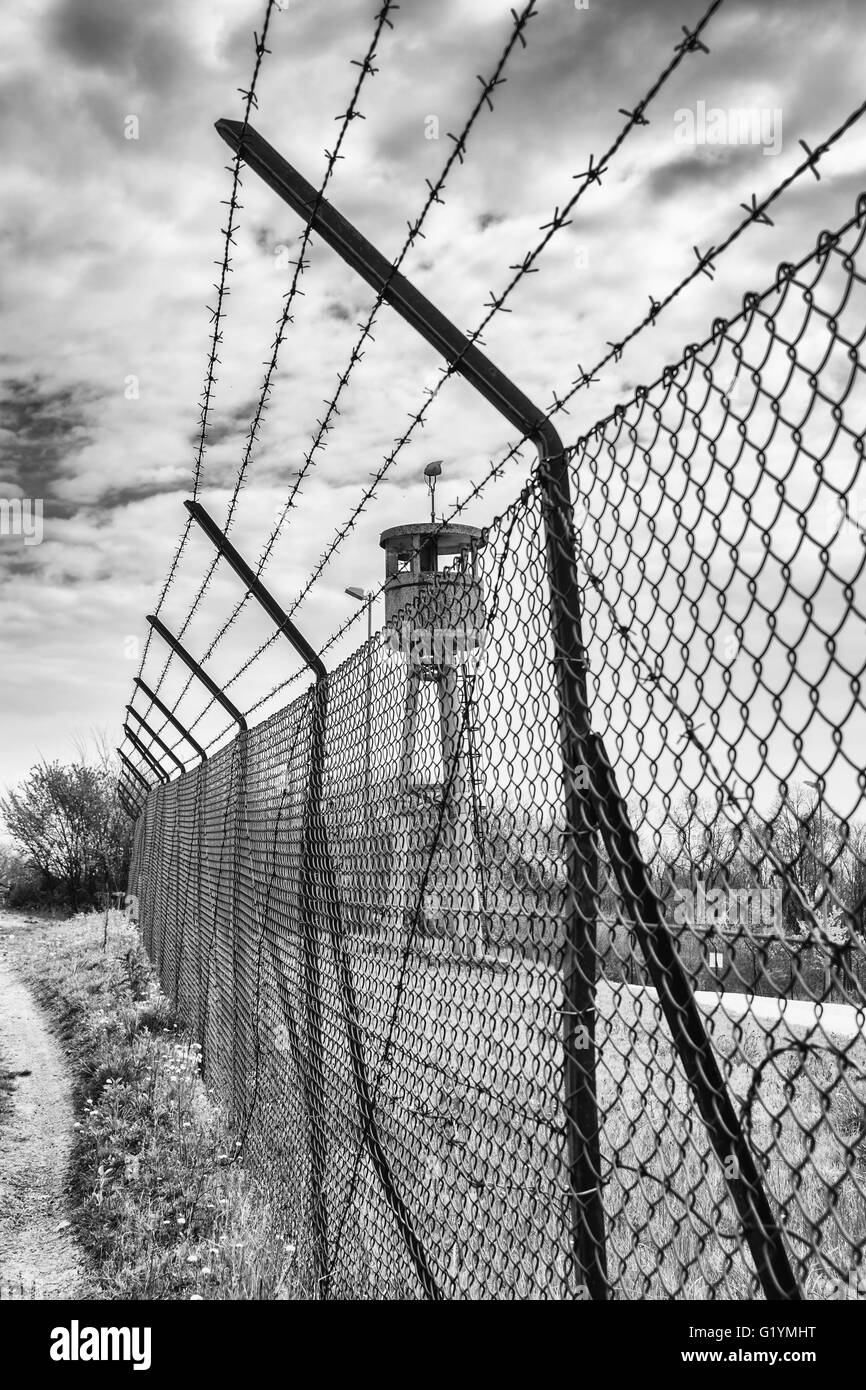 Abbandonato torre di avvistamento isolata da un netto e rabboccato con filo spinato. Foto Stock