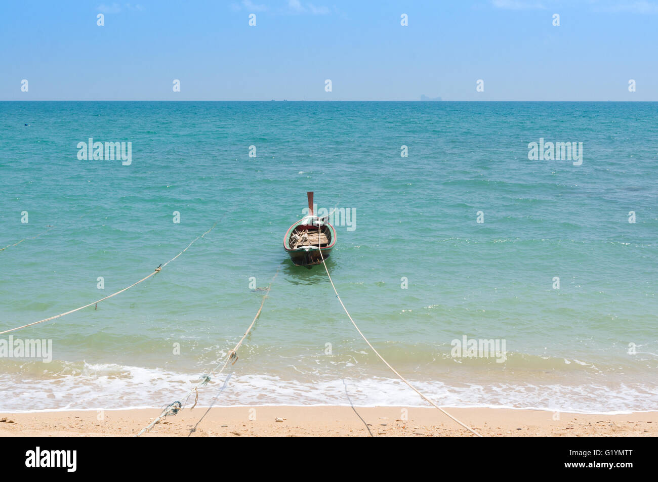 Longtail-Boat ancorato sulla spiaggia di Koh Lanta con fune. Bellissimo oceano turchese e il cielo limpido. Foto Stock