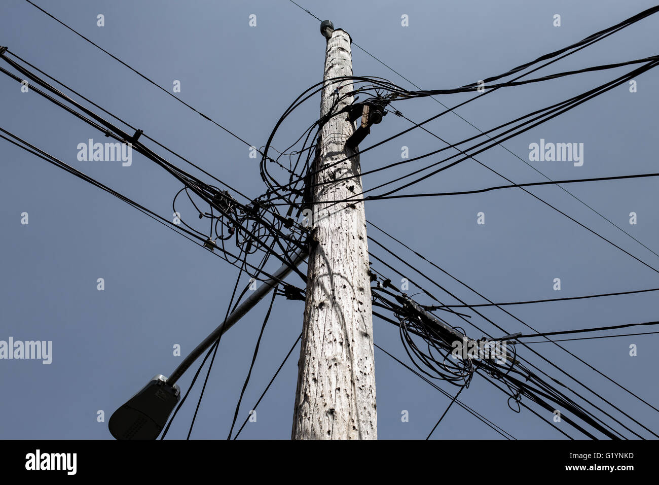 Guardando il cavi convergenti in un palo telefonico Foto Stock