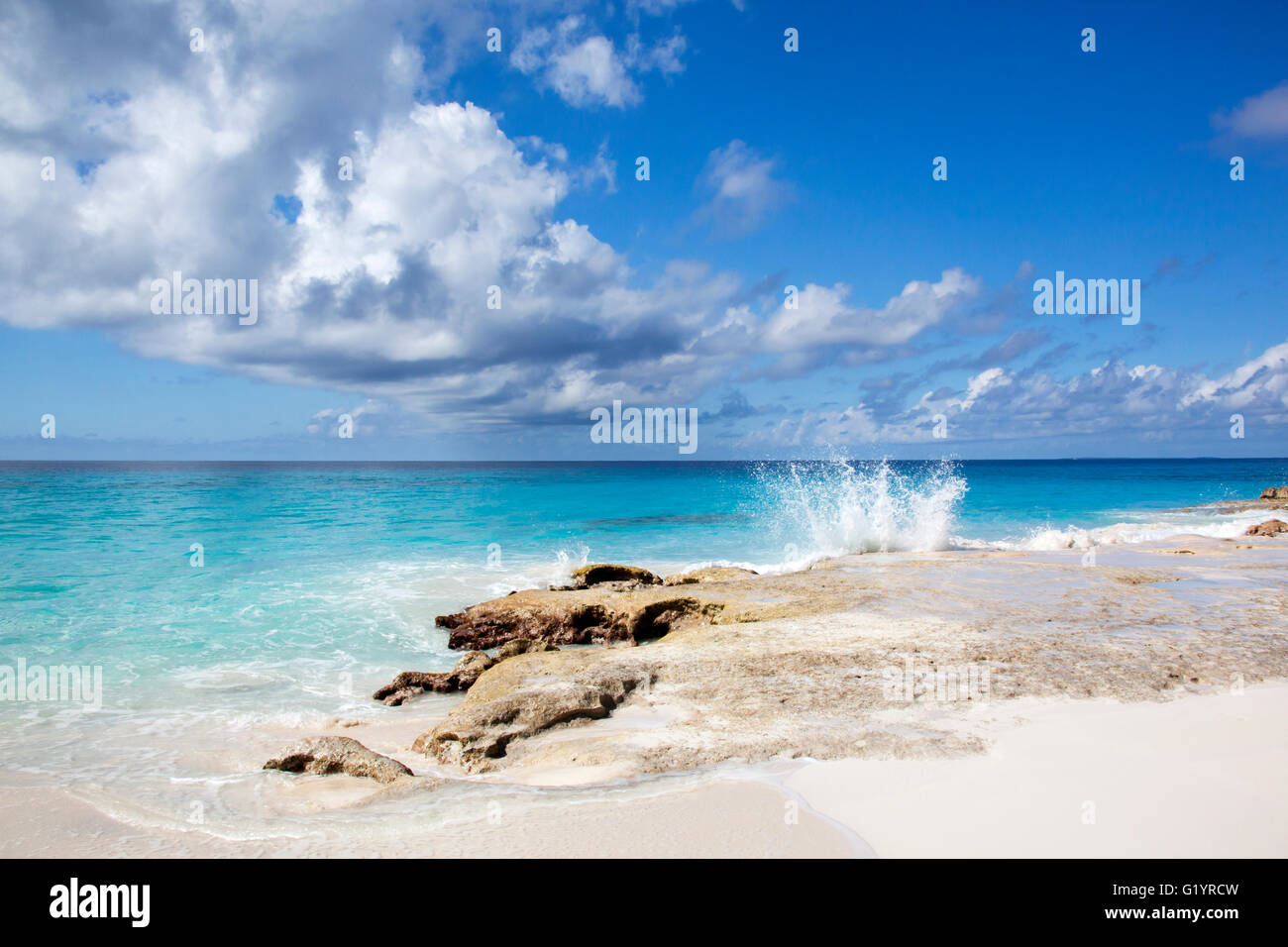 L'onda schizzi in riva di isola disabitata di Half Moon Cay (Bahamas). Foto Stock
