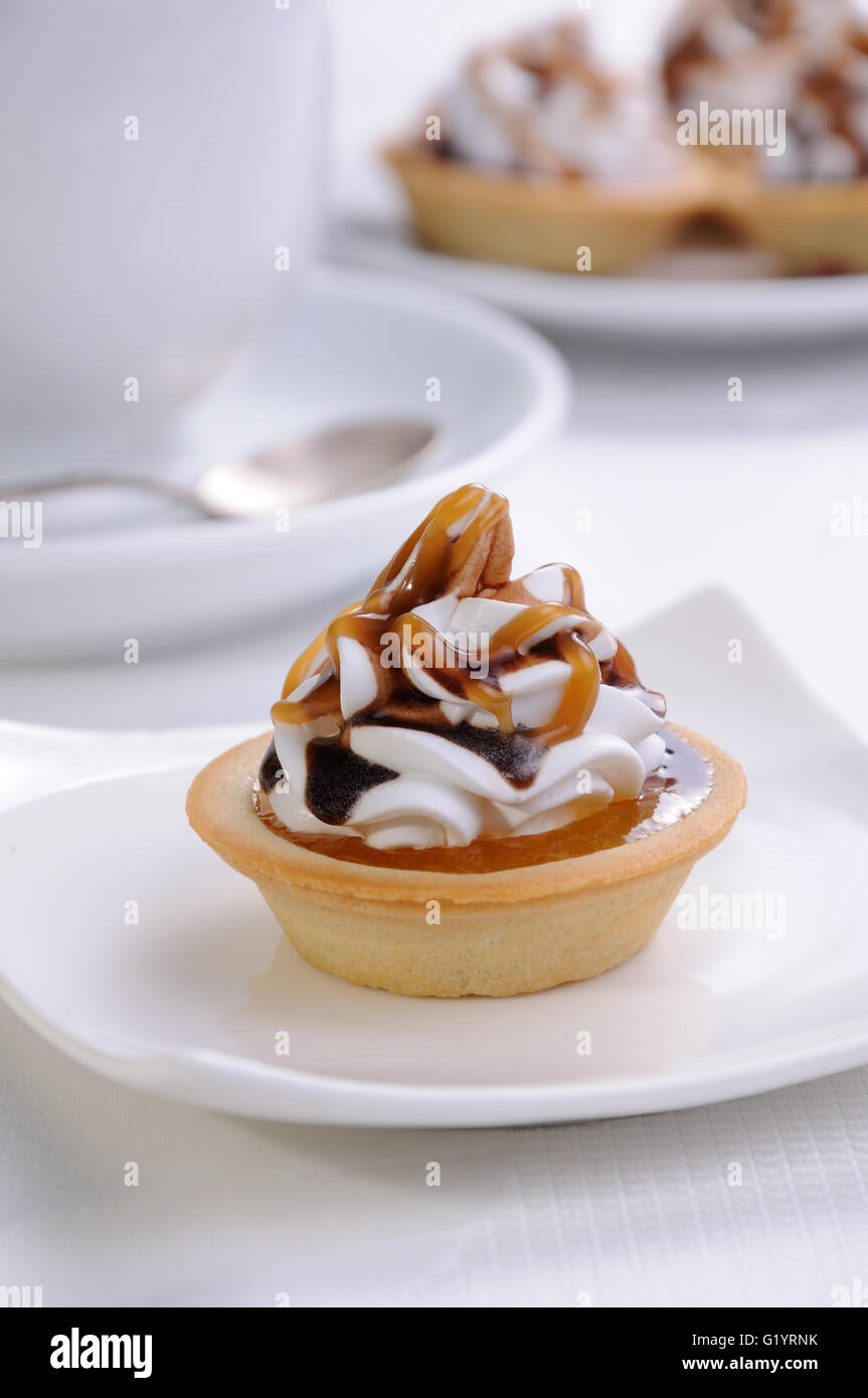 Frollini сakes inceppamento riempiti con panna e cioccolato topping caramel Foto Stock