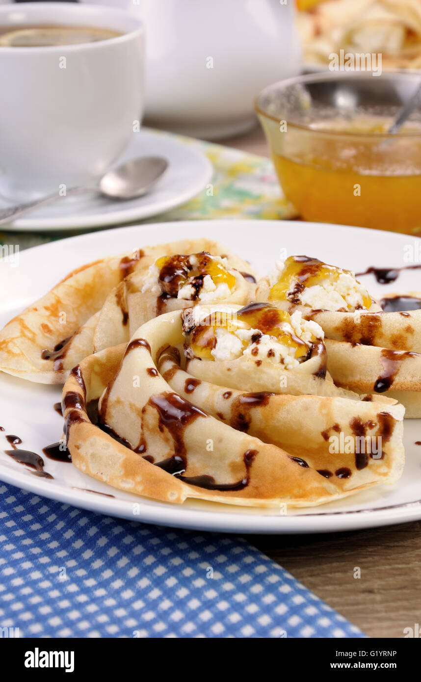 Pancake piegato nella forma di una lumaca per la ricotta con il cioccolato Foto Stock