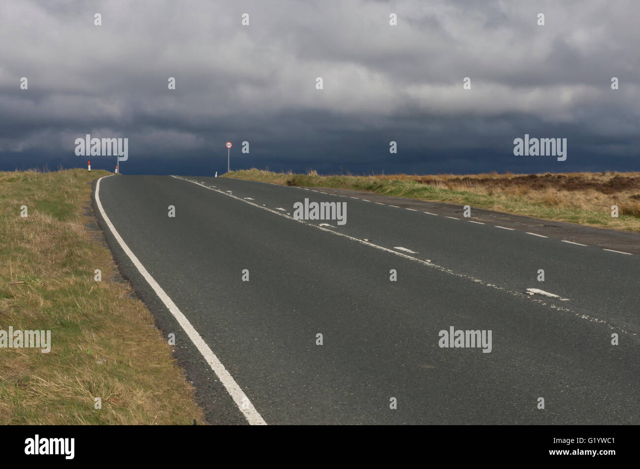 Nuvole temporalesche oltre il ciglio di una collina su un deserto, paese, moorland road tra Baildon e Eldwick, West Yorkshire, Inghilterra. Foto Stock