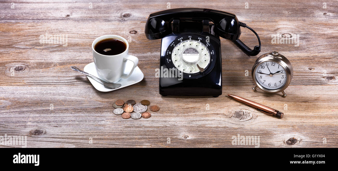 Vintage desktop con antichi manopola telefono, orologio, penna, monete e caffè. Foto Stock