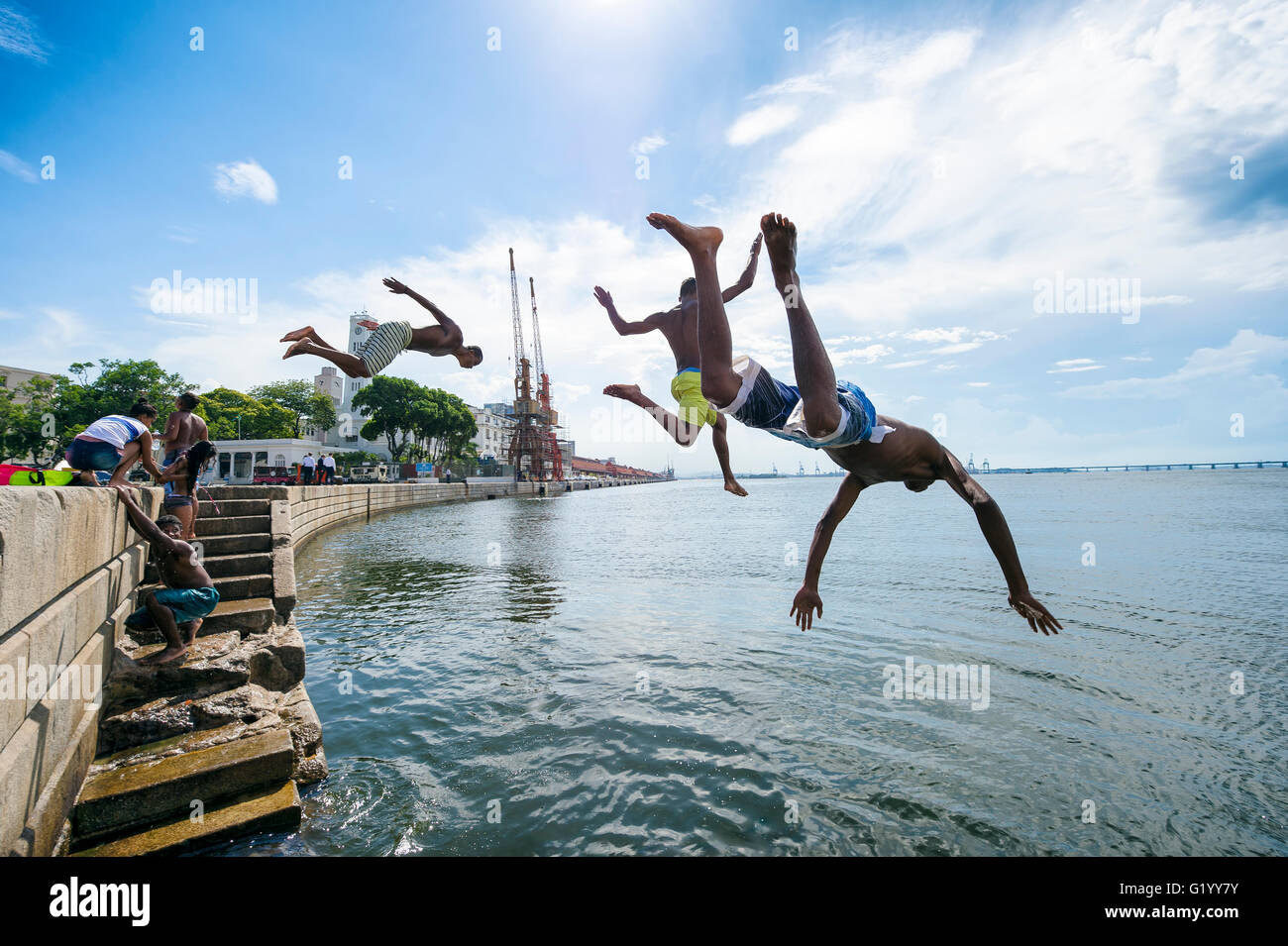 RIO DE JANEIRO - Febbraio 25, 2016: i giovani brasiliani salto nella baia di Guanabara da una parete di Maua Plaza a Porto Maravilha. Foto Stock