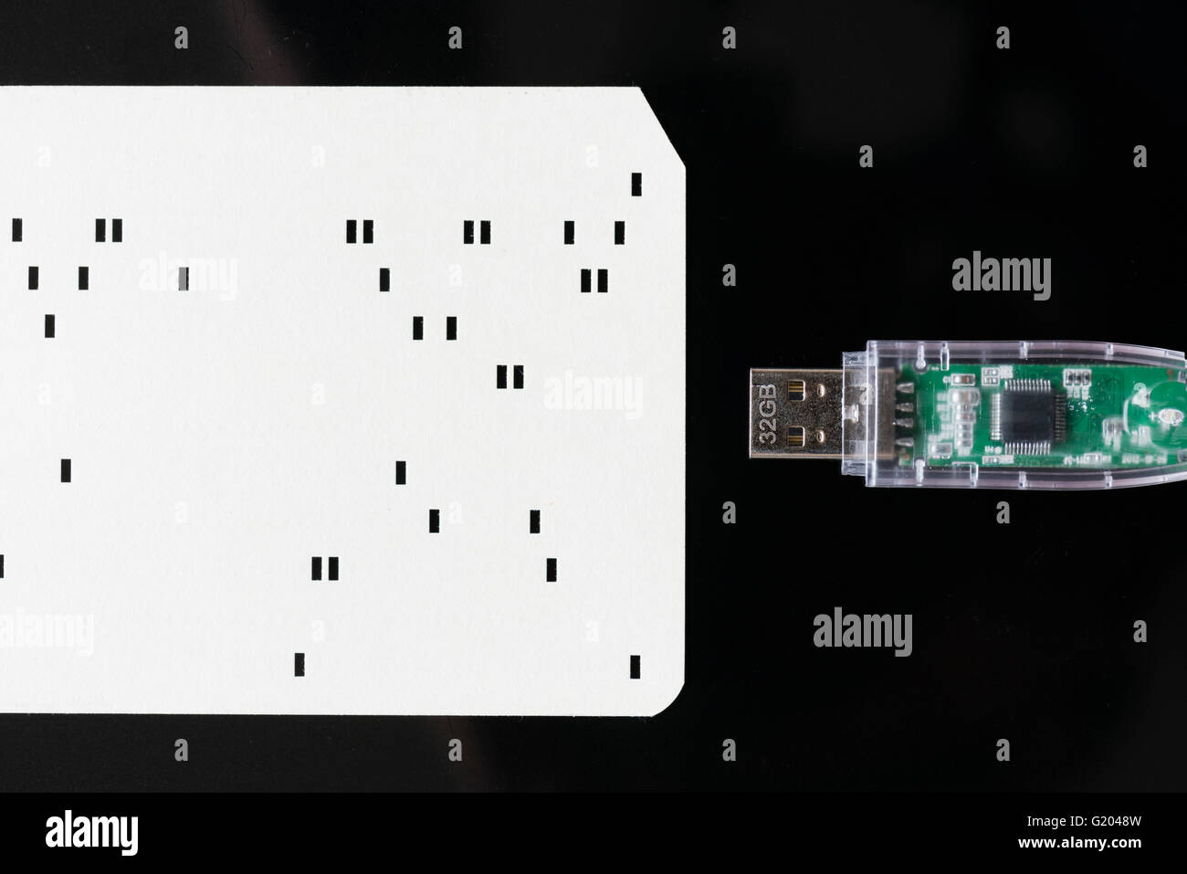 Close-up di un moderno 32GB memory stick USB dal 2016 accanto alla storica primi computer punch card (circa dal 1970) Foto Stock