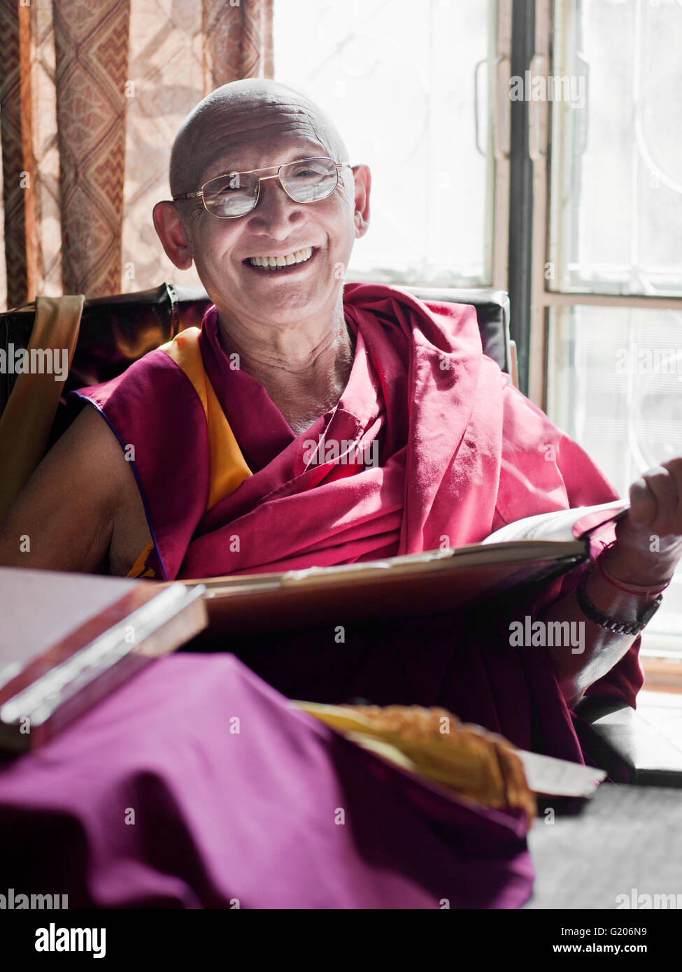 Ghesce Sonam Rinchen legge un testo buddista in preparazione per l'insegnamento di una classe presso la biblioteca di opere tibetano e archivi. Foto Stock