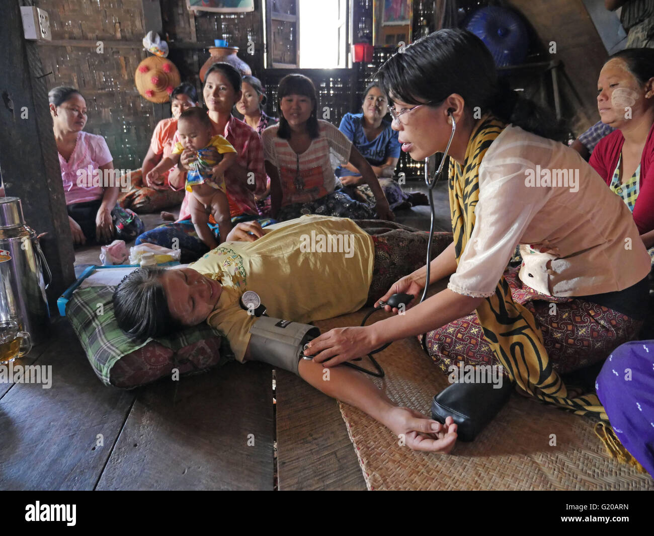 MYANMAR Hlaing Thayer, una delle baraccopoli della capitale Yangon dove le persone sono stati riposizionati dopo il 2008 Typhoon. MCHAN è attiva in questo settore con la sua comunità basata programma sanitario. Visitare una casa dove MCHAN esegue health check-up e conduce il workshop. MCHAN infermiera Monica Myu imbardata Hli esaminando la donna incinta e prendendo la sua pressione del sangue. Foto Stock