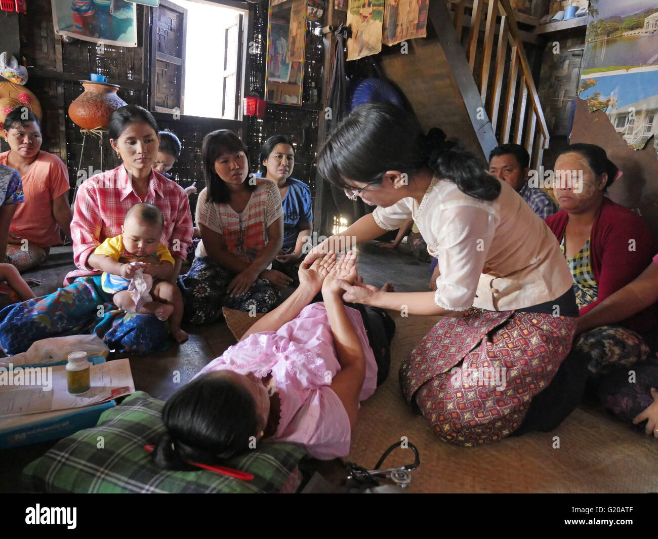 MYANMAR Hlaing Thayer, una delle baraccopoli della capitale Yangon dove le persone sono stati riposizionati dopo il 2008 Typhoon. MCHAN è attiva in questo settore con la sua comunità basata programma sanitario. Visitare una casa dove MCHAN esegue health check-up e conduce il workshop. MCHAN infermiera Monica Myu imbardata Hli esaminando la donna incinta e prendendo la sua pressione del sangue. Foto Stock