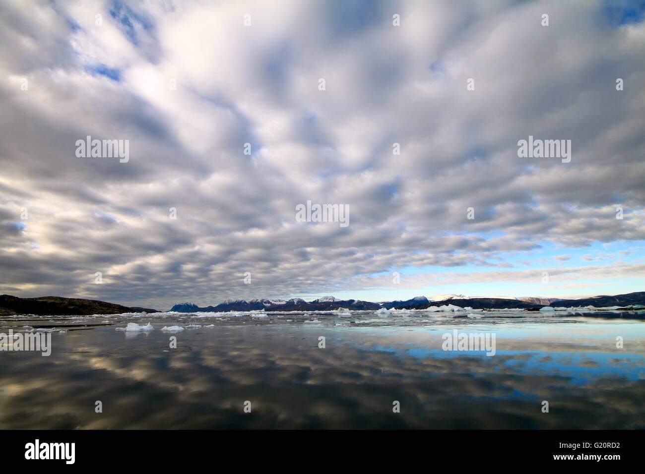 Nuvole riflettono sull'acqua al fiordo di Sermilik, Groenlandia orientale Foto Stock