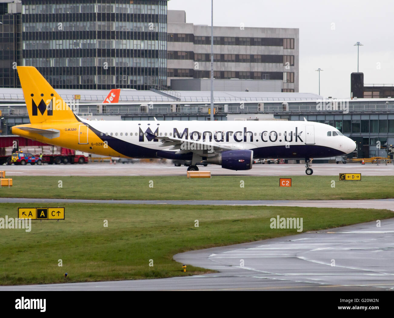 La Monarch Airlines Airbus A320 corpo stretto piano passeggero (G-OZBY) rullaggio per la partenza all'Aeroporto Internazionale di Manchester. Foto Stock