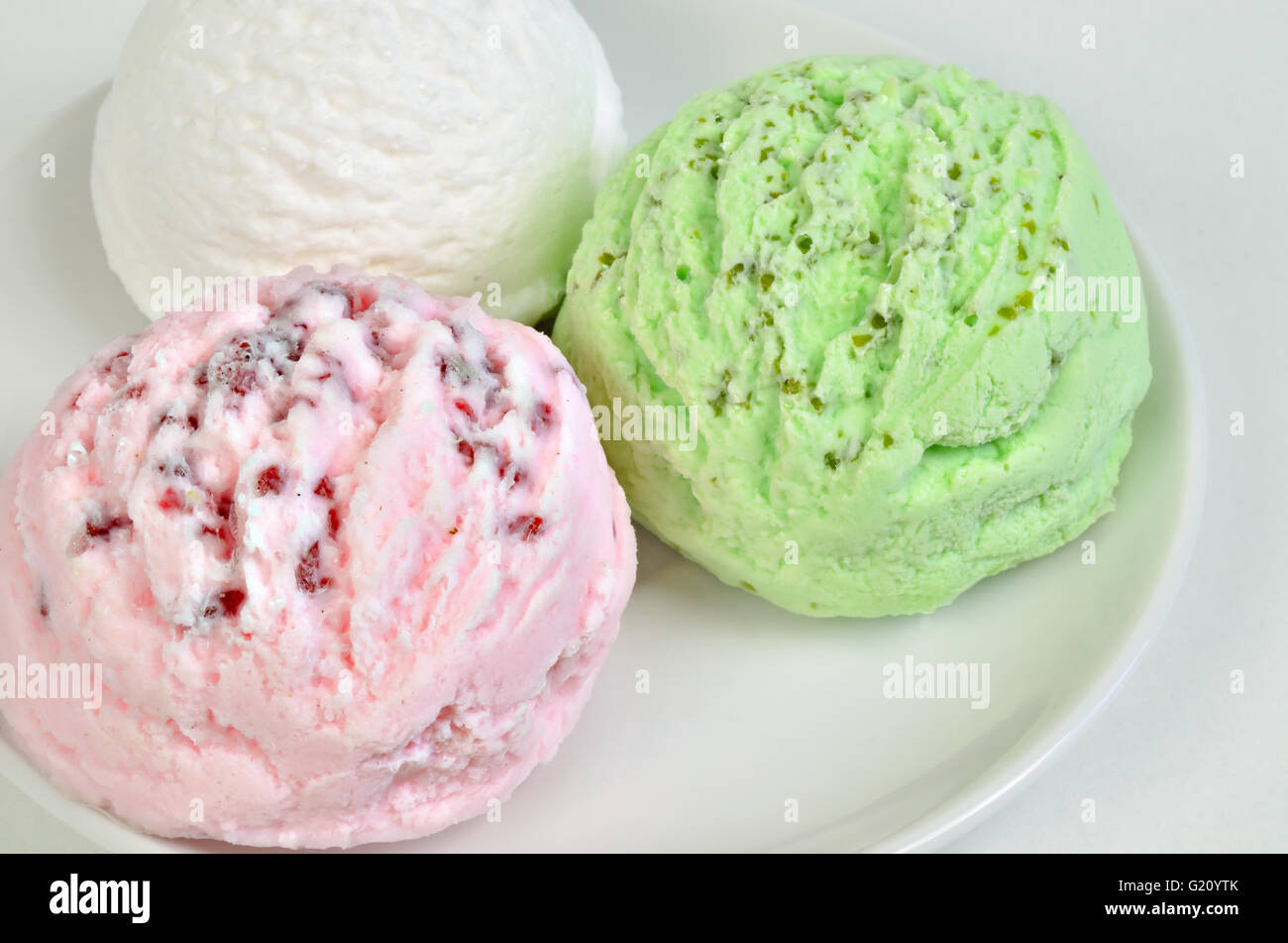 Tre palline di verde, bianco e gelato su piastra bianca, close up, full frame, orizzontale Foto Stock