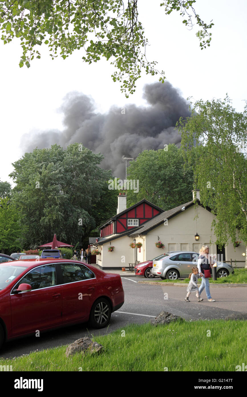 Worcester Park, Surrey, Regno Unito. 21 maggio 2016. Nuvole di nero fumo billowing aumento da un incendio su B284 Vecchio Malden Lane in Worcester Park, Surrey. A circa 19.30 più equipaggi di fuoco, la polizia e le ambulanze hanno partecipato al fuoco accanto al Hogsmill Toby Carvery Pub. La polizia ha confermato che la combustione di pneumatici presso un cantiere industriale ha causato la quantità eccessiva di fumo di scarico nero. Da circa 8.00pm il fuoco era sotto controllo. Credito: Julia Gavin UK/Alamy Live News Foto Stock