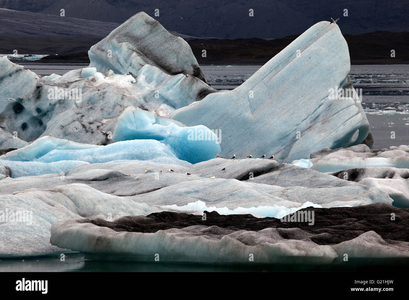 Ice Iceberg, con tracce di ceneri vulcaniche, ghiacciaio, il lago glaciale del ghiacciaio Vatnajökull, Jökulsarlon, Islanda Foto Stock