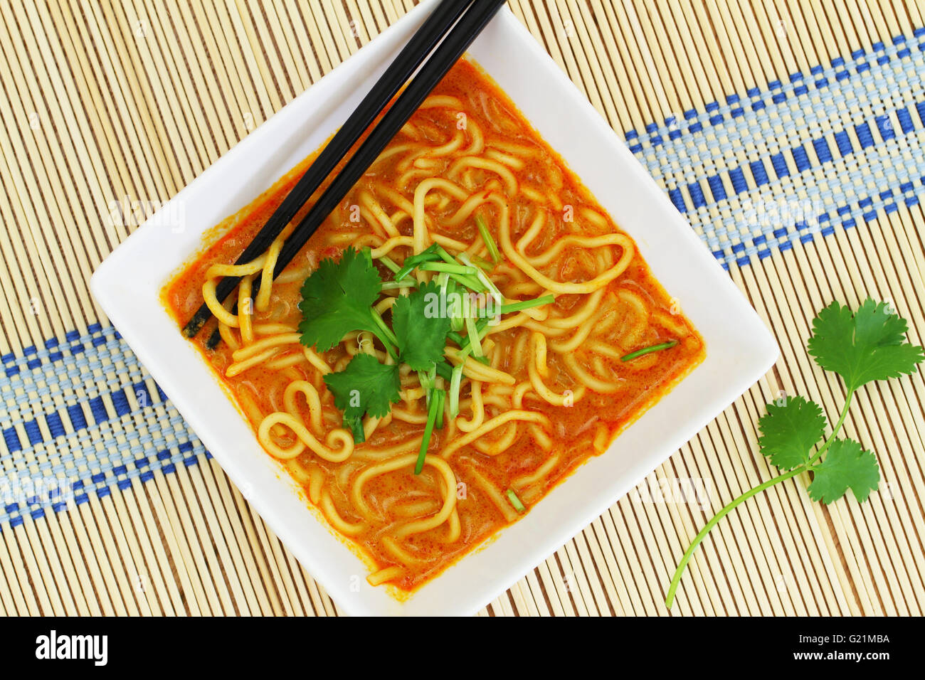 Hot Curry zuppa di noodle nella ciotola sul tappetino di bambù Foto Stock