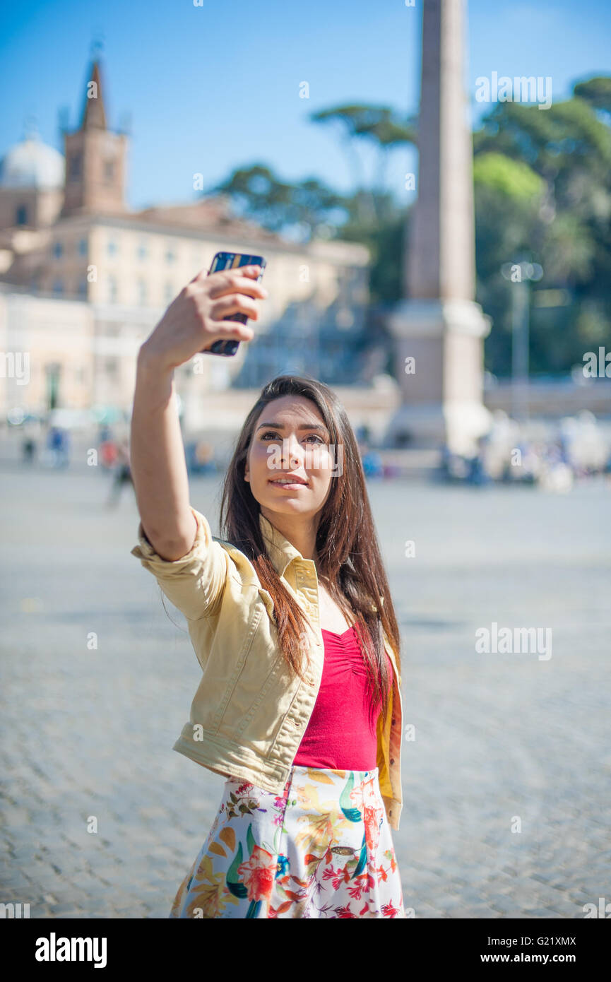 Giovane donna turistica prendendo selfie foto con telefono mobile a Roma in piazza del popolo Foto Stock