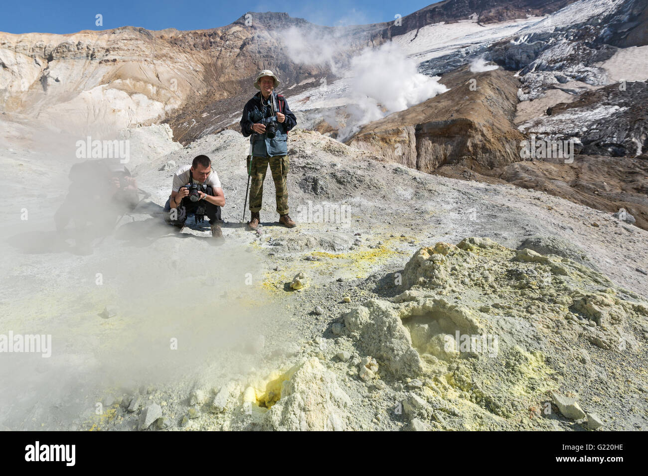 Fotografi nel cratere del vulcano Mutnovsky vicino attive fumarole di zolfo, espulsione di vapore e gas. Penisola di kamchatka. Foto Stock