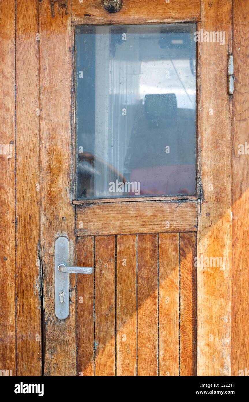 Vecchio brown porta di legno sulla nave con una finestra Foto Stock