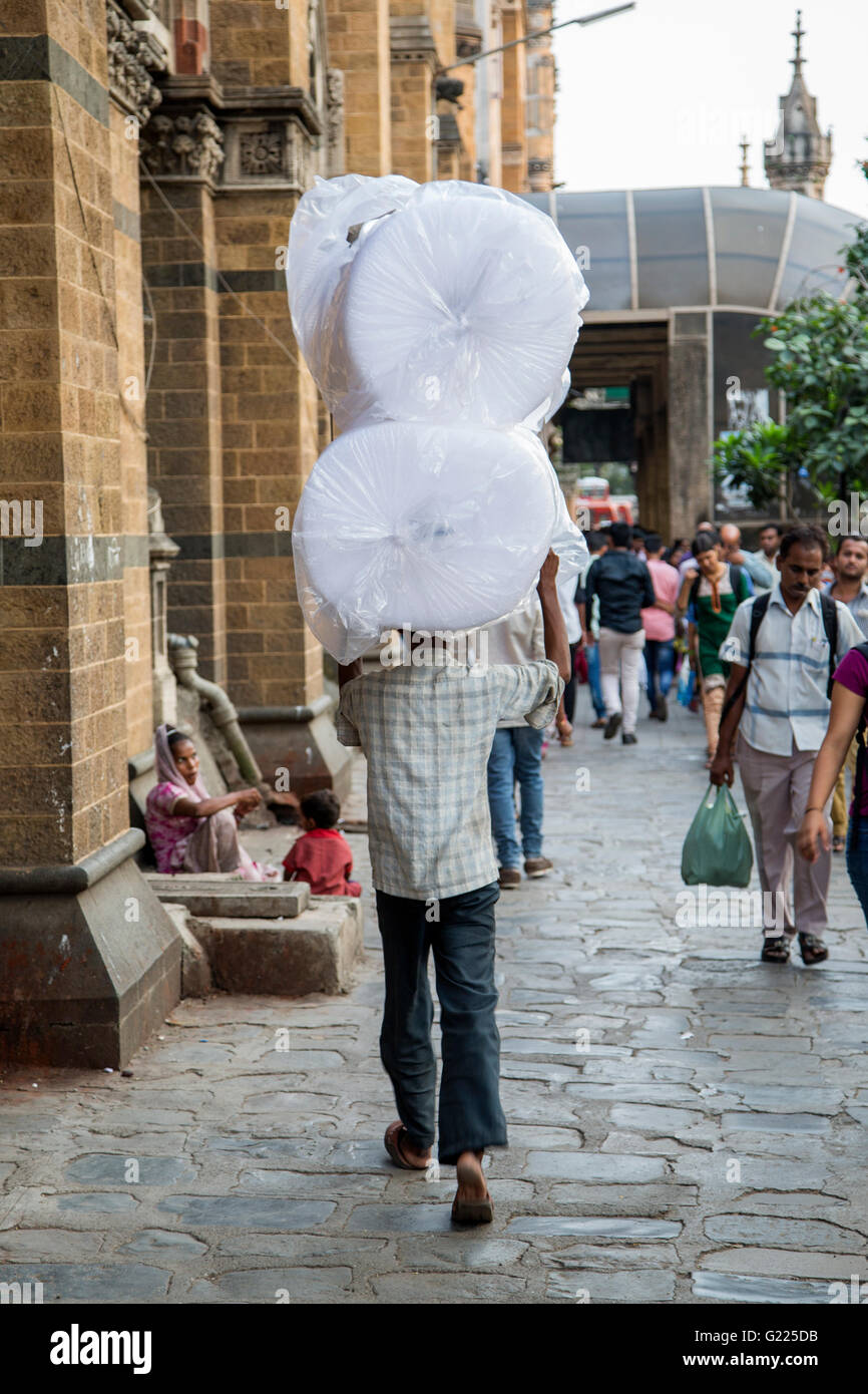 MUMBAI, India - 9 ottobre 2015: l'uomo non identificato carryng peso sulla sua testa. Le persone hanno portato equilibrata degli oneri sulla parte superiore del Foto Stock