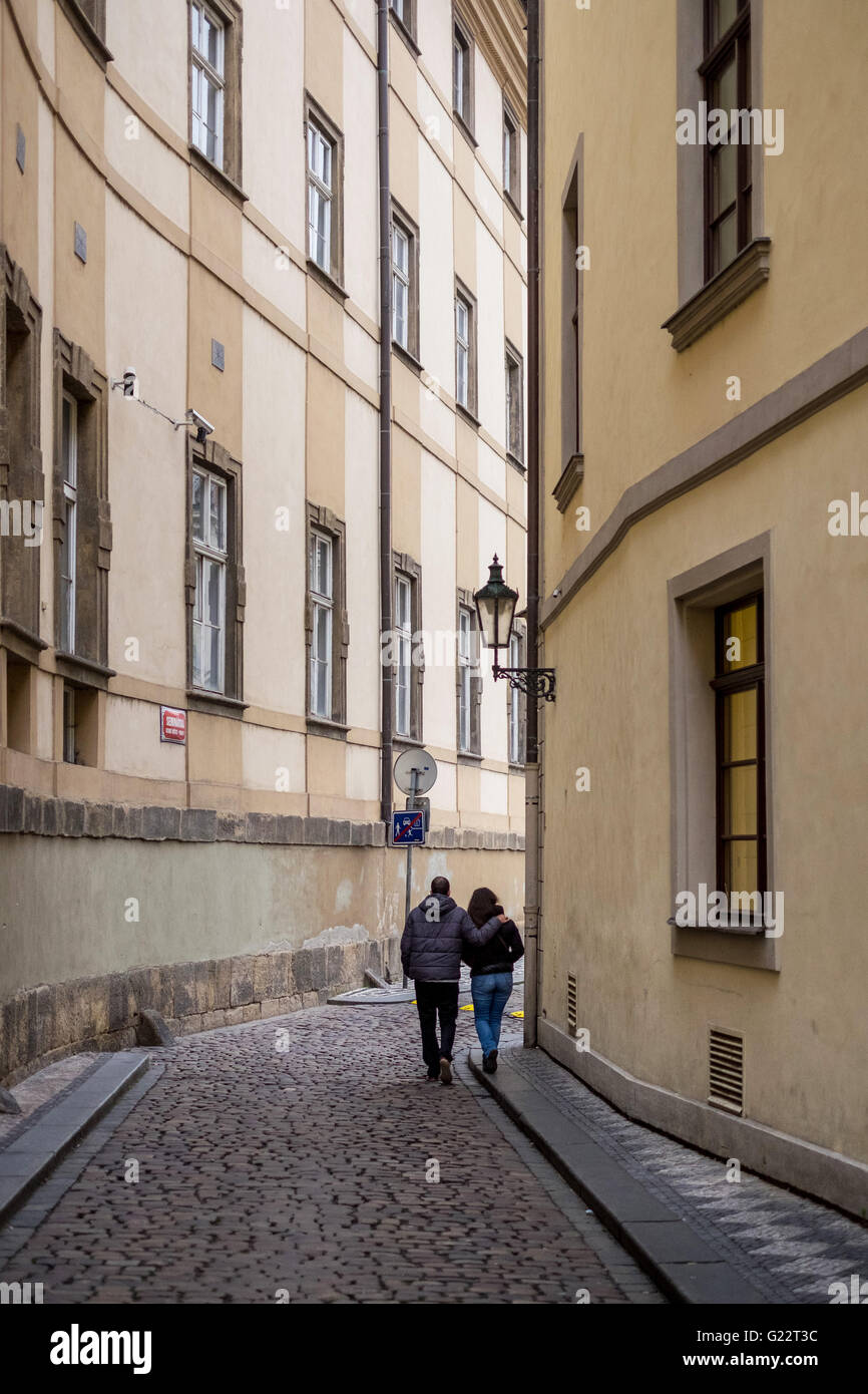 Una giovane coppia fare il loro modo a braccetto attraverso i vicoli della citta' vecchia di Praga, Repubblica Ceca. Foto Stock
