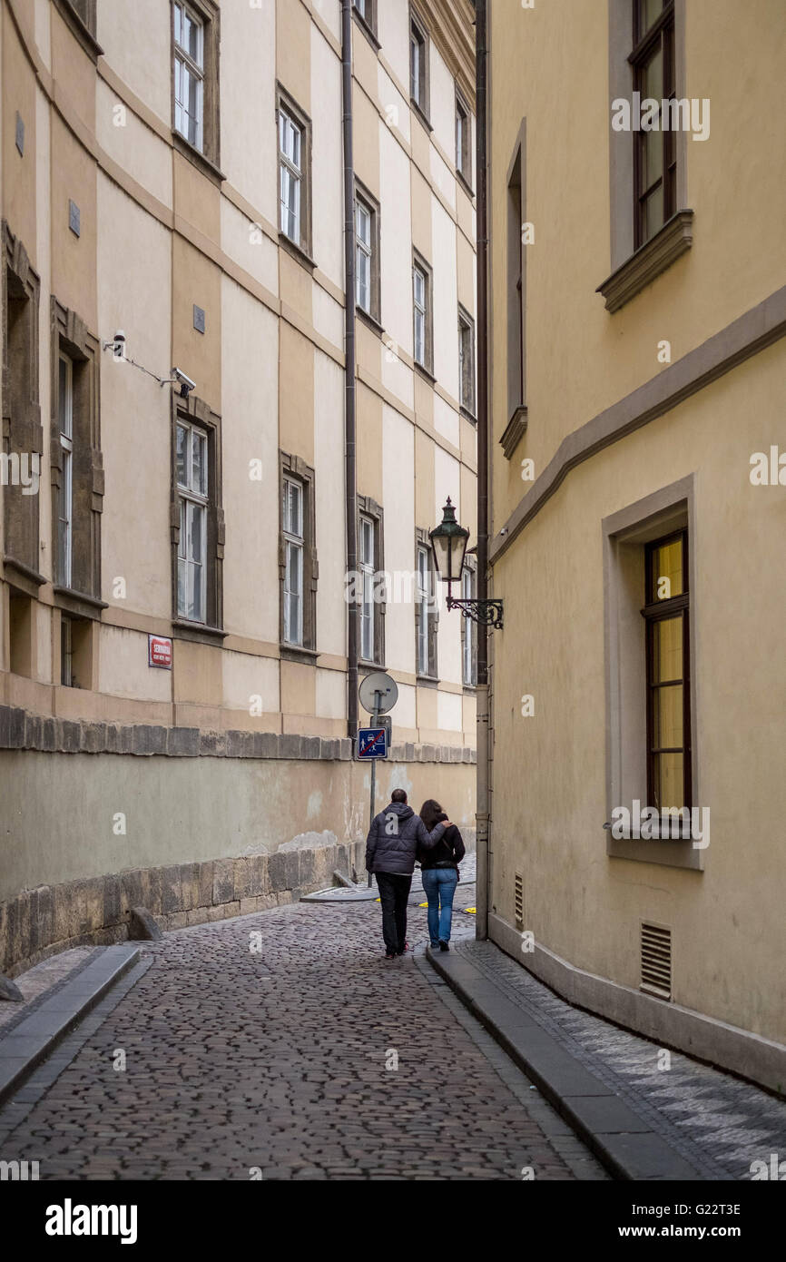 Una giovane coppia fare il loro modo a braccetto attraverso i vicoli della citta' vecchia di Praga, Repubblica Ceca. Foto Stock
