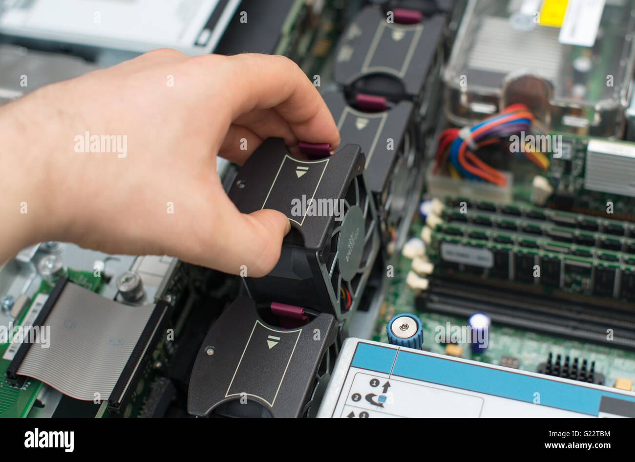 Tecnico informatico Installazione ventola dello scambiatore di calore nella scheda madre. Foto Stock