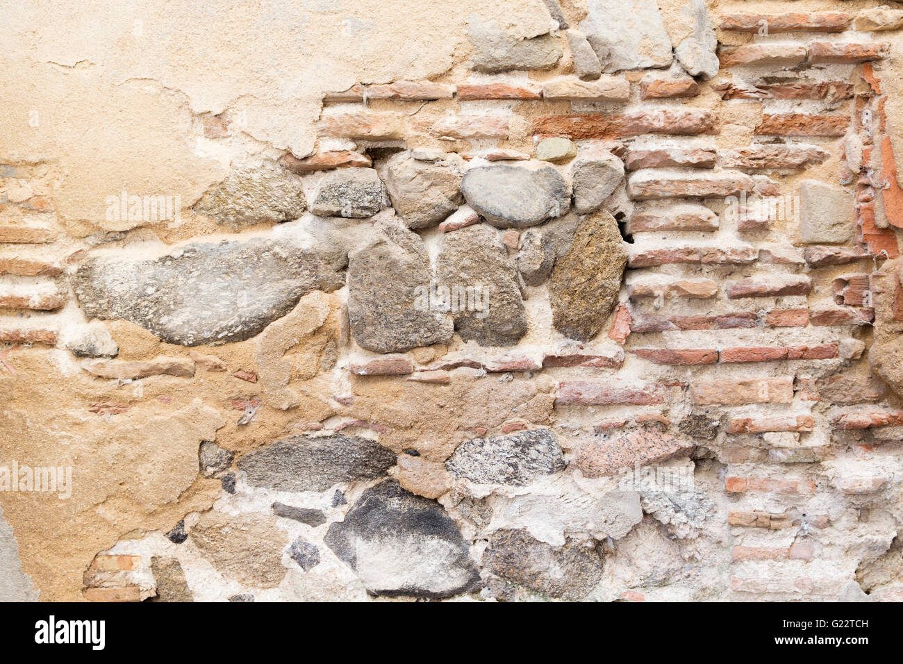Close-up di usurati muro fatto di mattoni e pietra ricoperta con moss Foto Stock