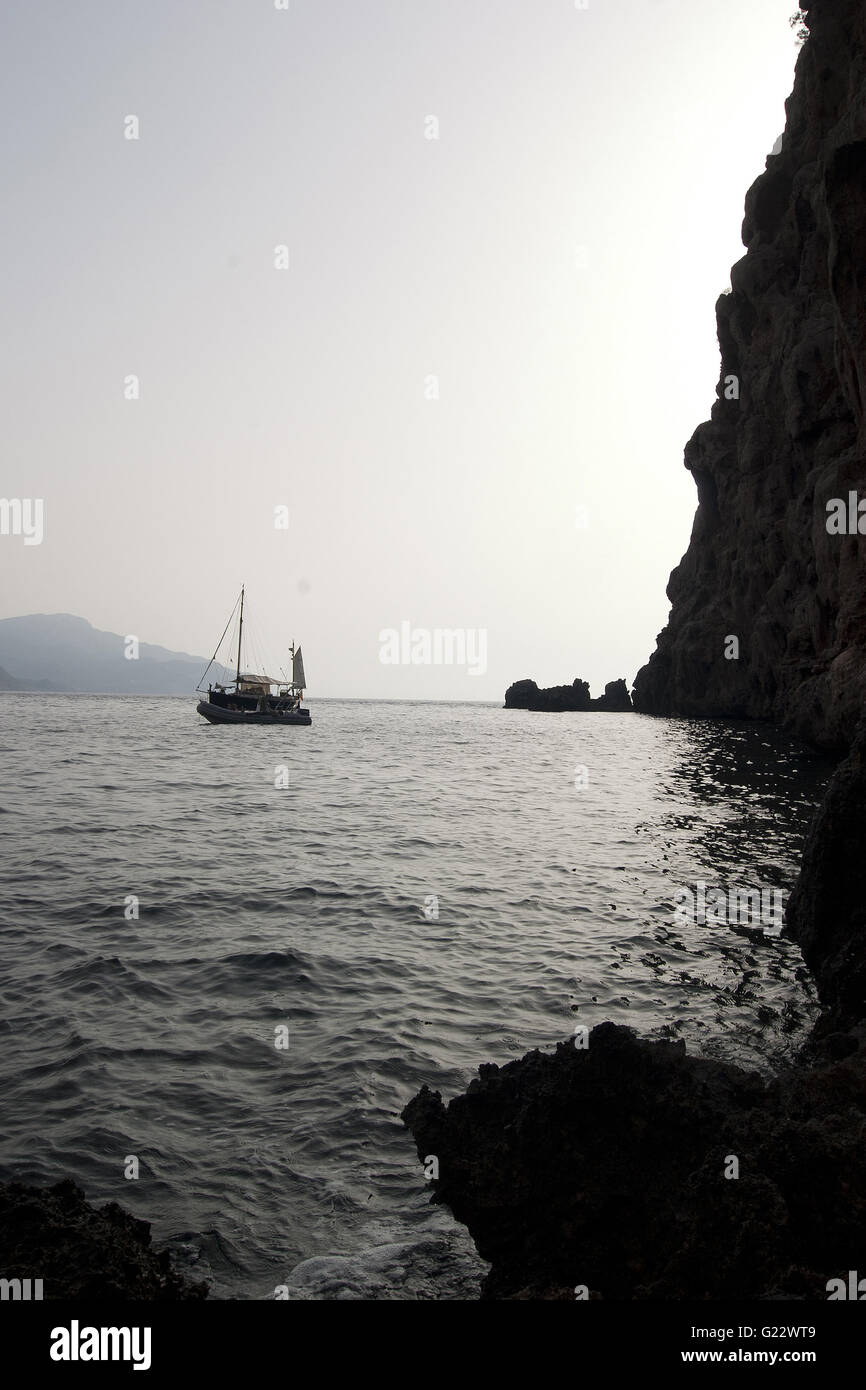 Una bella immagine in verticale di rocky stagliano ingresso con una barca sulla costa di Palma de Mallorca, Spagna, mare turismo Foto Stock