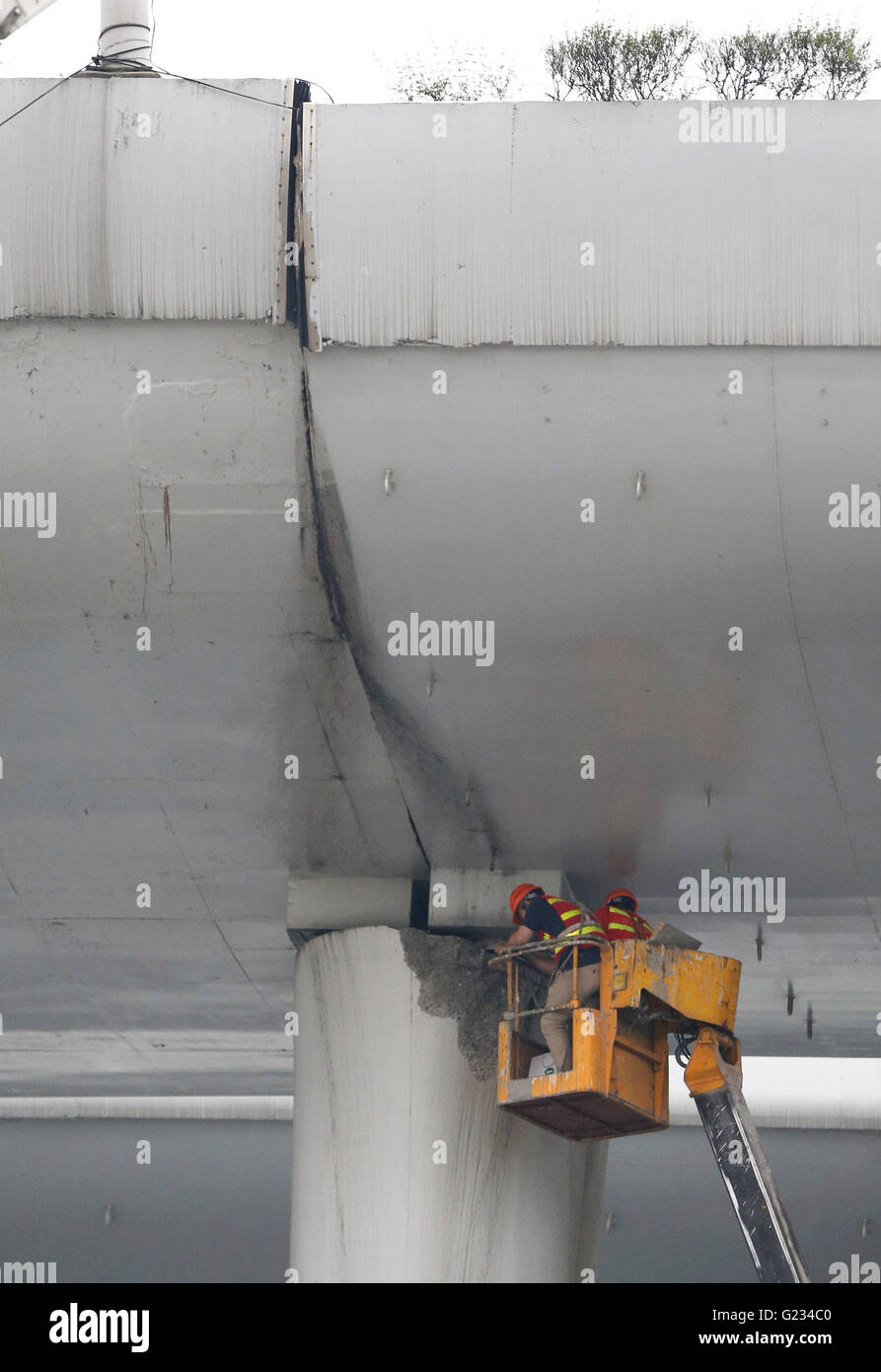 Shanghai. 23 Maggio, 2016. I lavori di riparazione è in corso dopo un over-carrello caricato capovolto su un ponte di mezzo anello stradale nell est della Cina di Shanghai, 23 maggio 2016. Il carrello caricato con tubazioni in calcestruzzo ha spinto sul ponte illegalmente e rovesciato, causando una grande rottura sul ponte. Senza lesioni o incidenti sono stati segnalati. Credito: Pei Xin/Xinhua/Alamy Live News Foto Stock