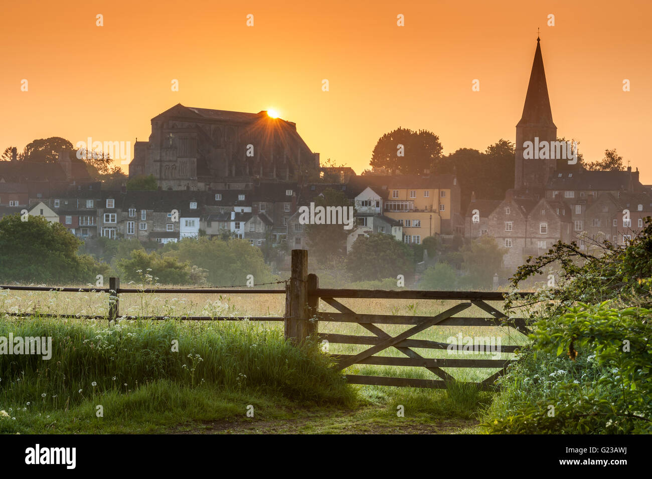 Malmesbury, Wiltshire, Regno Unito. Xxiv Maggio, 2016. Il sole sorge alle spalle l'antica abbazia nel Wiltshire città di Malmesbury in maggio. Credito: Terry Mathews/Alamy Live News Foto Stock
