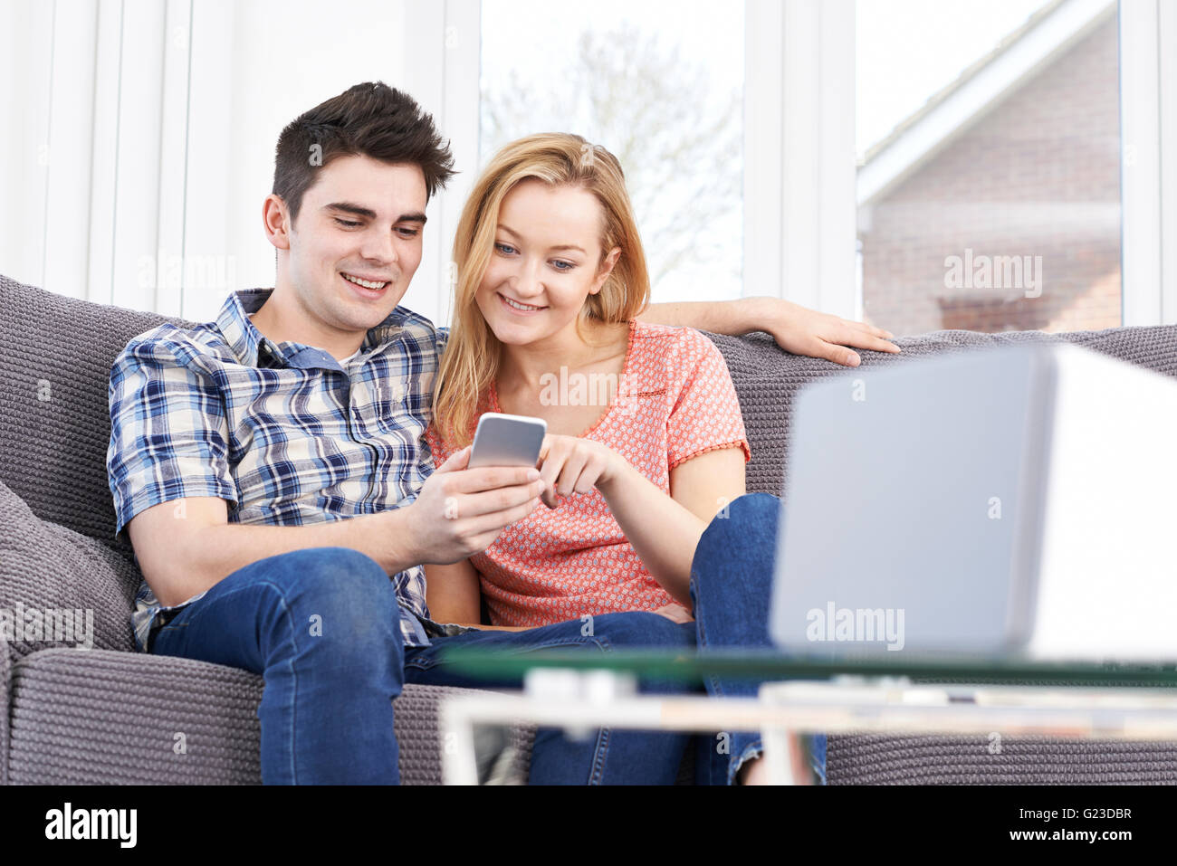 Giovane lo streaming di musica dal telefono cellulare per altoparlante senza fili Foto Stock