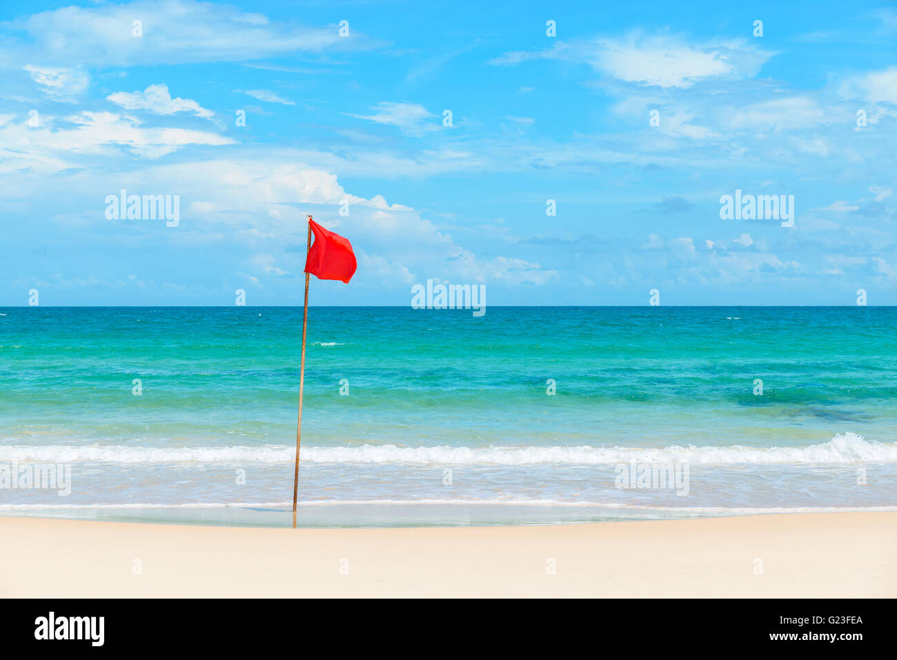 Bandiera rossa sulla spiaggia tropicale e mare azzurro Foto Stock