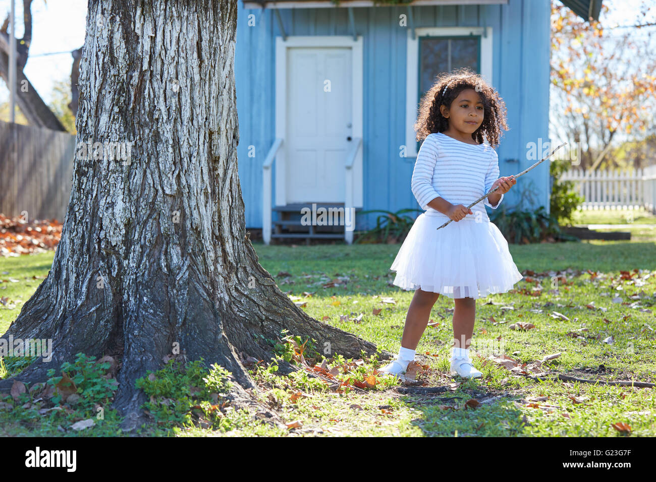 Kid toddler ragazza con il ramo stick giocando outdoor park etnia latina Foto Stock