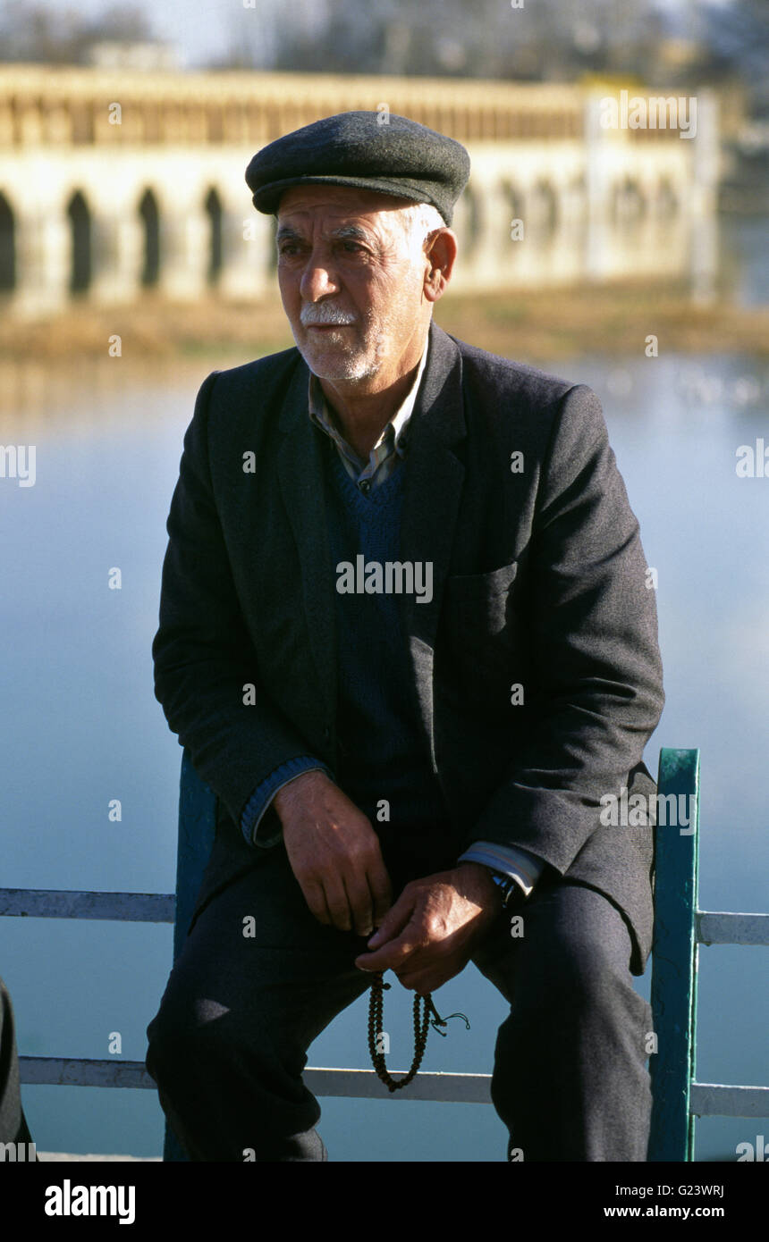 Ritratto di un anziano uomo iraniano appoggiata dal fiume Kawther in Isfahan. Foto Stock