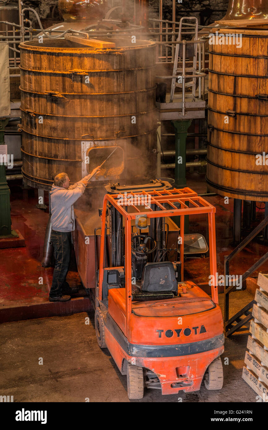 Uomo che lavora presso i serbatoi Washback nel Tun stanza a Dingle distilleria di whisky, in Dingle, nella contea di Kerry, Irlanda. Foto Stock