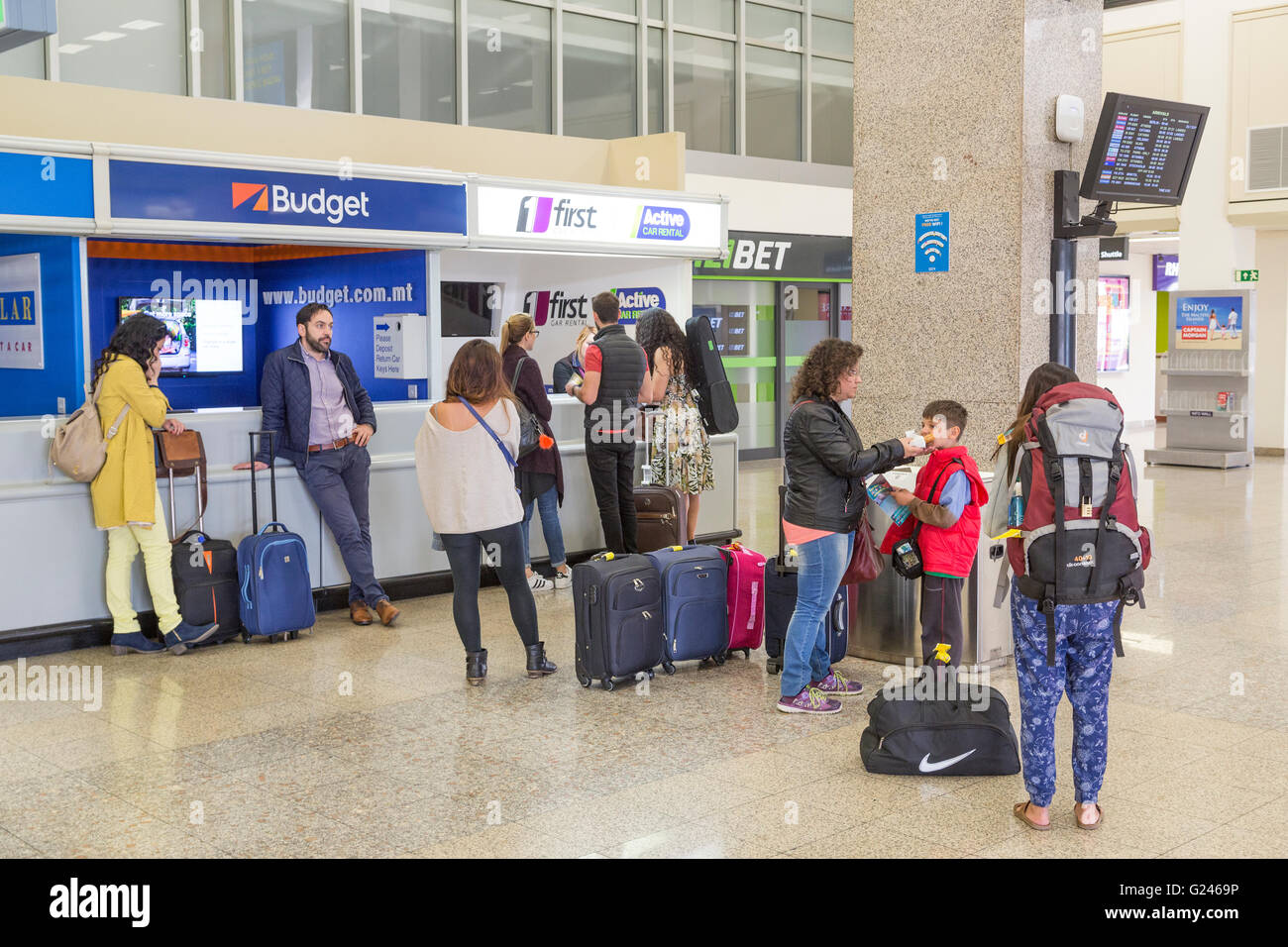 I passeggeri in coda per il noleggio di auto all aeroporto, Malta Foto Stock