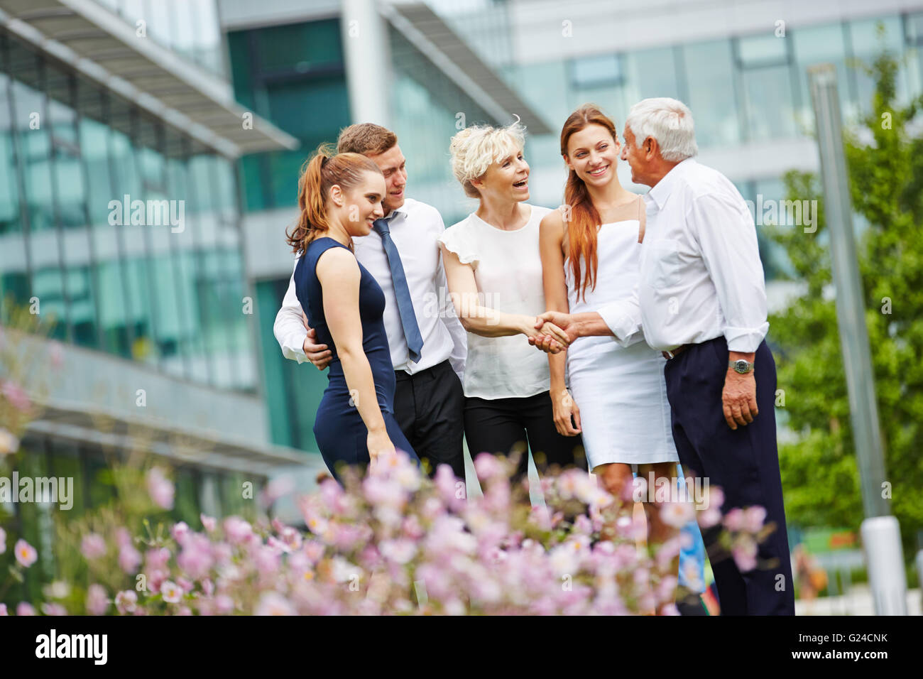 Congratulazioni per il successo del team aziendale con handshake di fronte all'ufficio Foto Stock