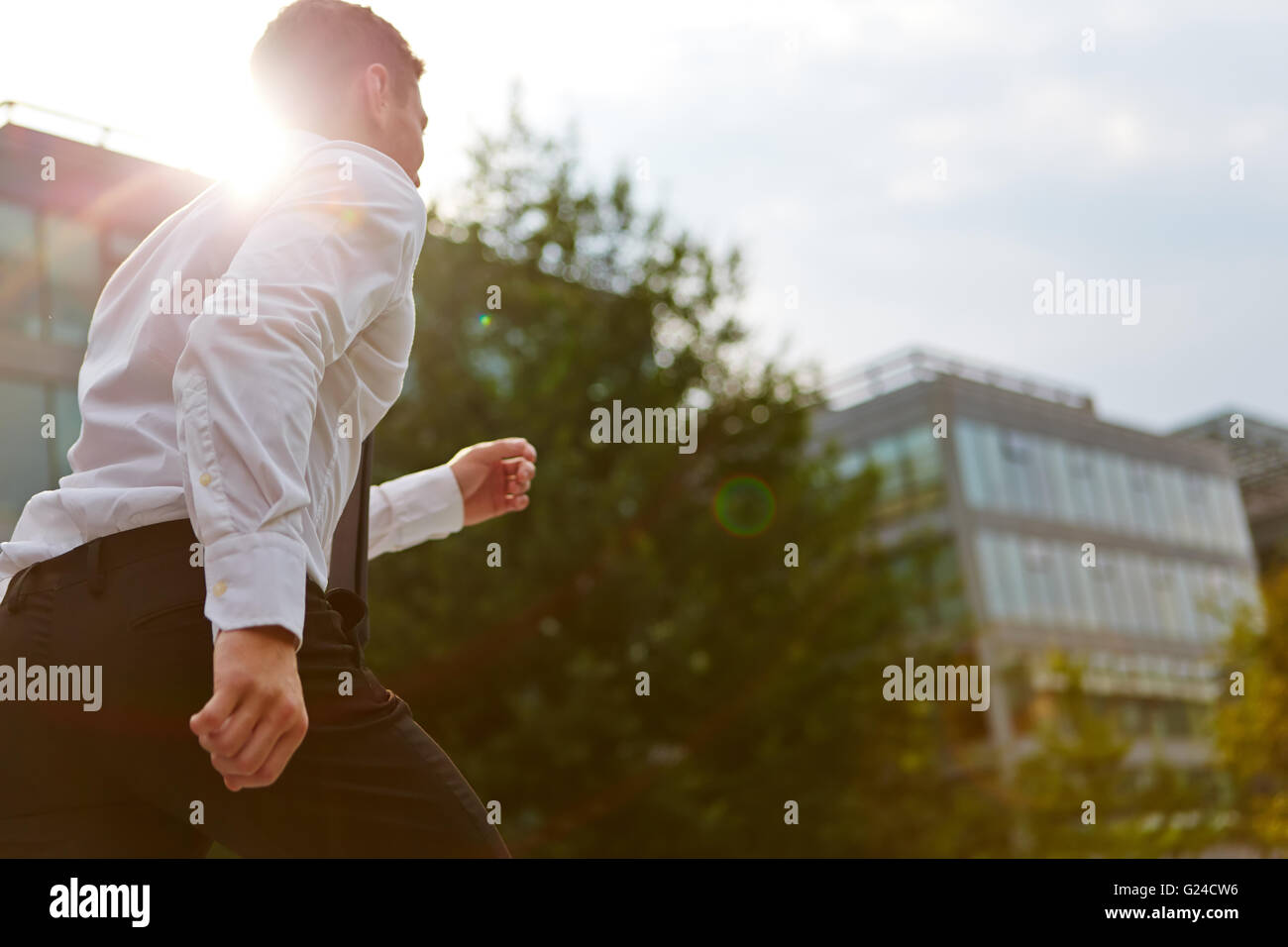 Active business man in esecuzione in città in estate con retro illuminazione Foto Stock