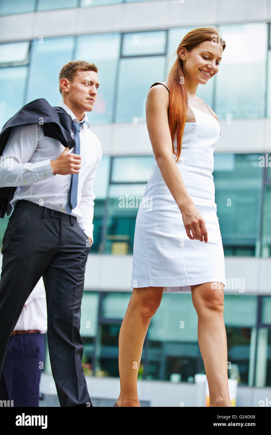 Uomo sorridente e felice donna in abbigliamento business per raggiungere a piedi il loro obiettivo Foto Stock