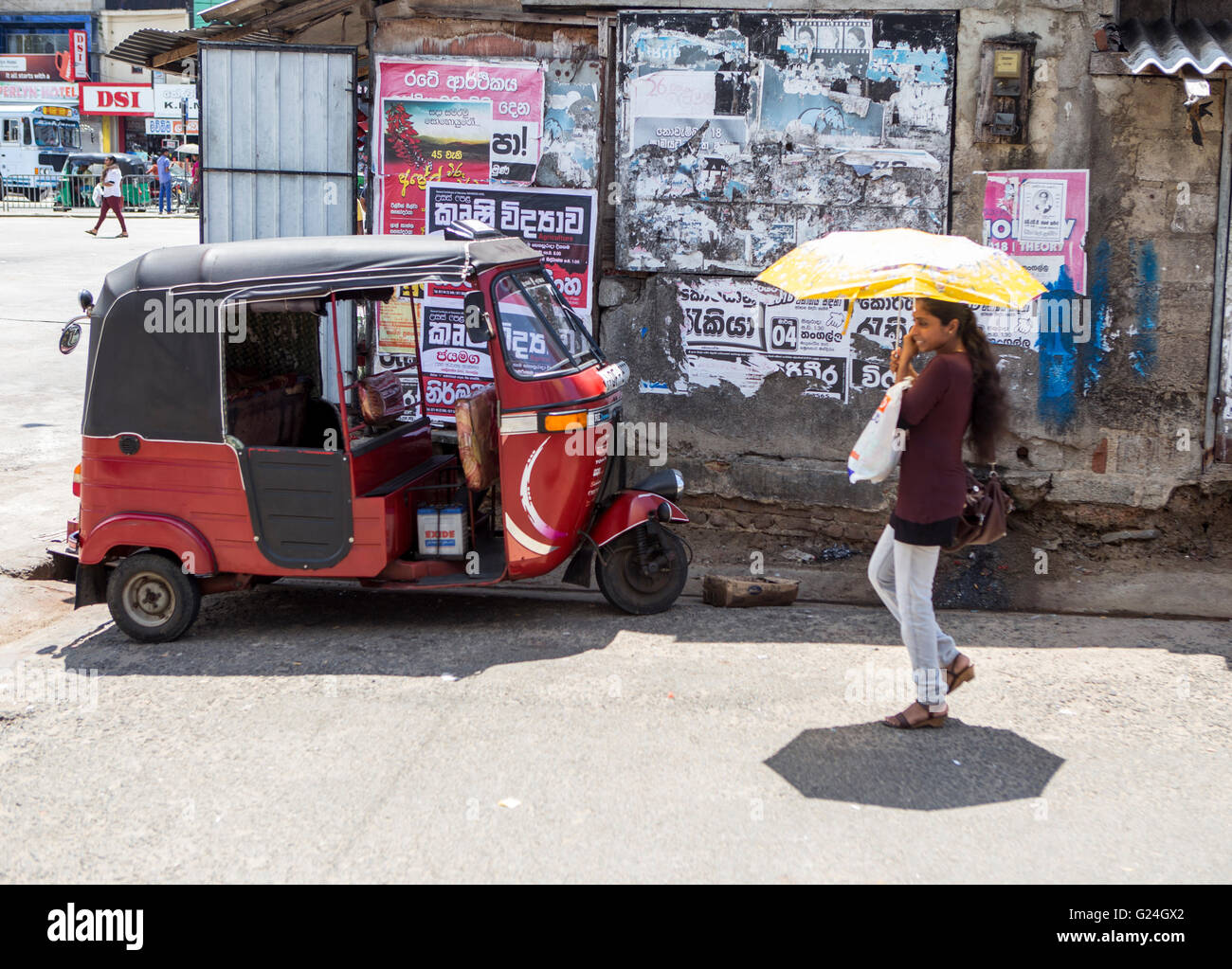 Tangalle , città nel distretto di Hambantota, sud della provincia, Sri Lanka, un tuk tuk rickshaw parcheggiato mentre una donna da passeggiate Foto Stock