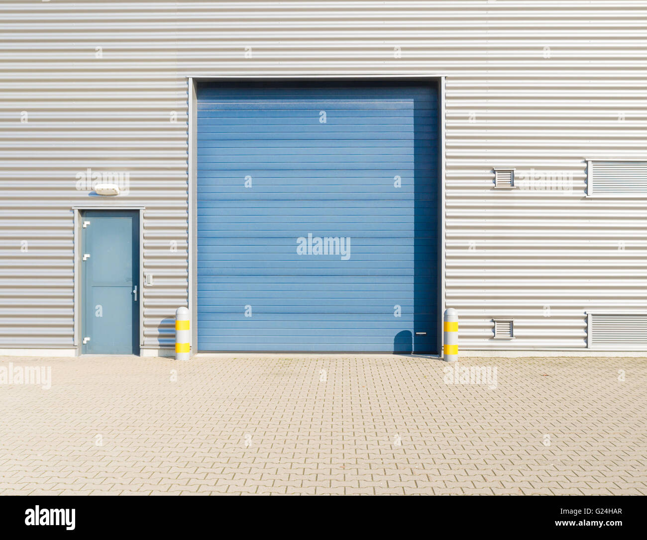 Magazzini industriali esterno con blu porta rullo Foto Stock