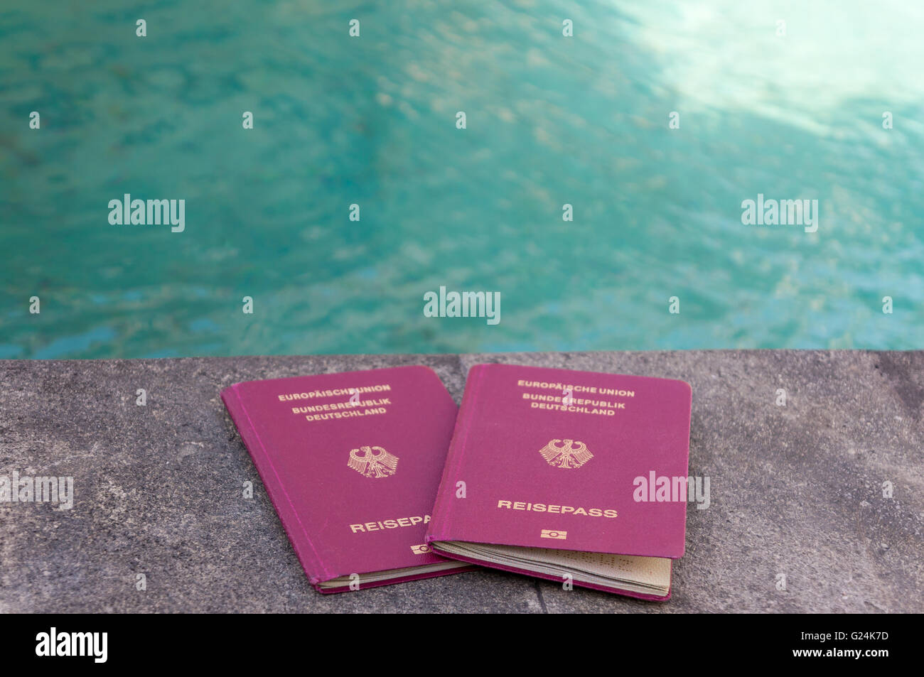 Due passaporti tedeschi di fronte all'acqua turchese. Sensazione di vacanza. Foto Stock