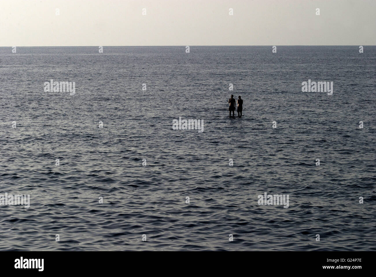 Una bella foto di due persone in piedi su una roccia in mezzo al mare, estate, turismo, natura, relax, vacanze Foto Stock