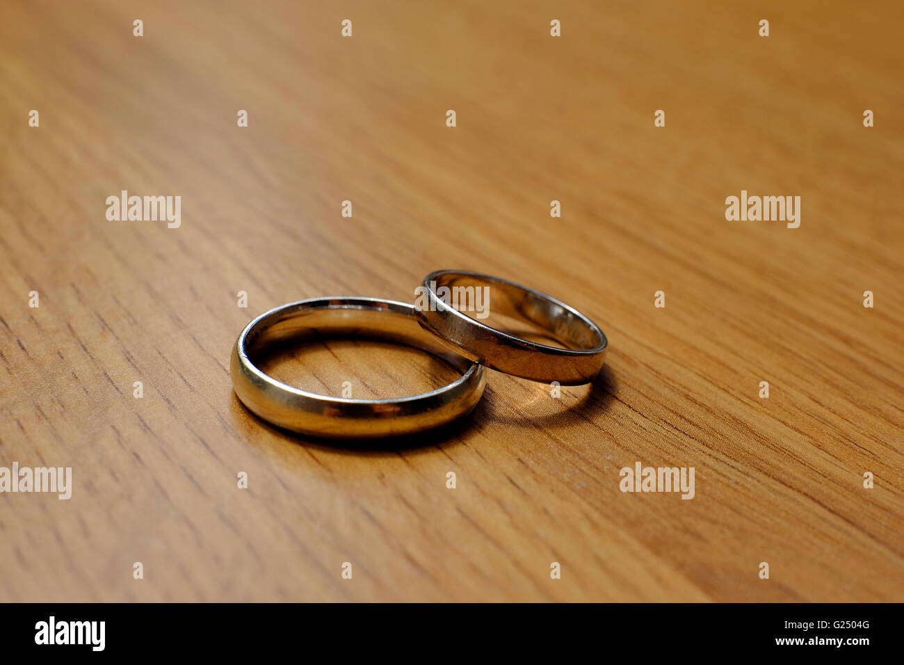 Due anelli di nozze, su di un tavolo di legno. Foto Stock