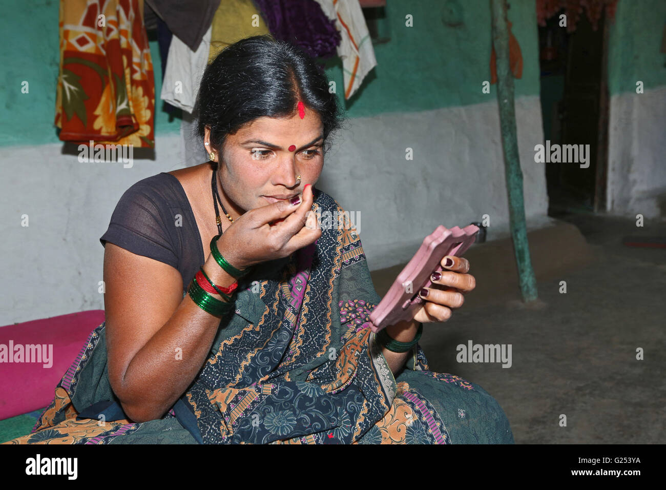 Tribù PARDHI - Donna di applicare il trucco. Ganeshpur village, Yawatmal District, Maharashtra, India Foto Stock